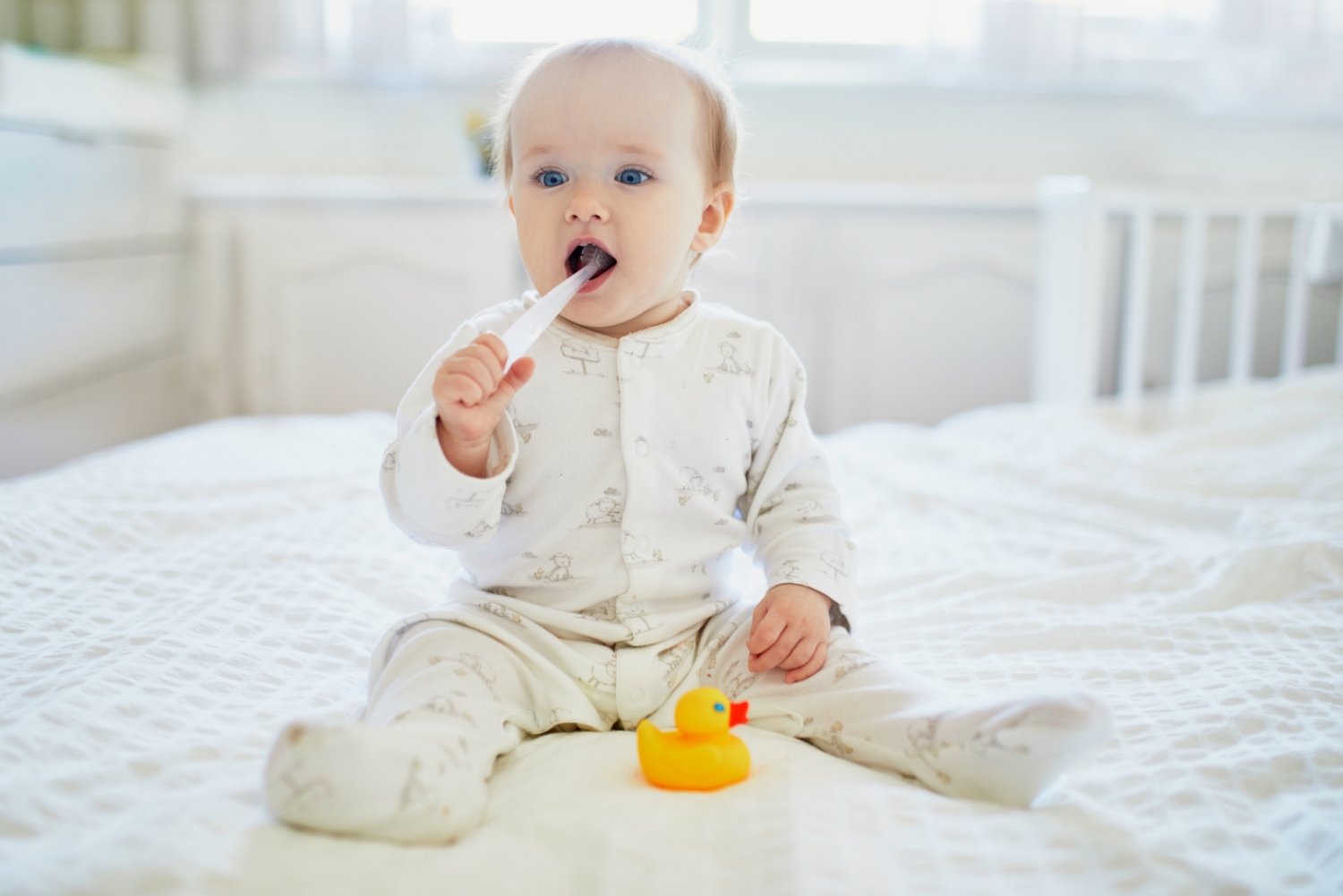 jednogodisnja beba drži četkicu za zube